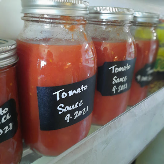 Jars full of homemade tomato sauce, ready to be frozen.