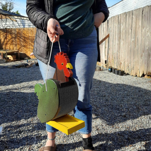 Amish made rooster birdfeeder. Handmade out of wood and painted with exterior paint. Held by an adult for size.