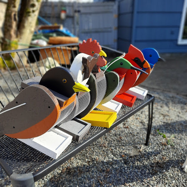 Amish made birdfeeders, blue bird, cardinal, hummingbird, rooster, owl and robin. All sitting on a bench together. Handmade and painted with exterior paint. Made in the USA!