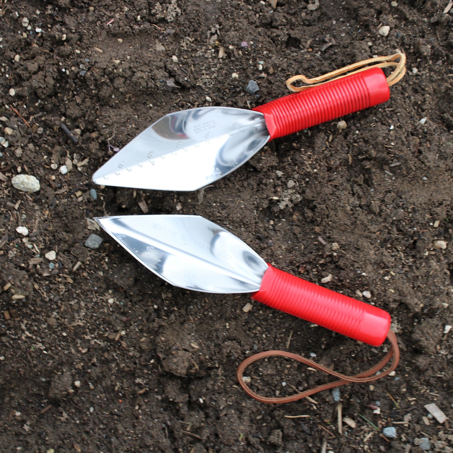Wilcox 10 inch gardener's trowel and 10 inch fine pointed trowel side by side, with red plastic handle and leather wrist strap